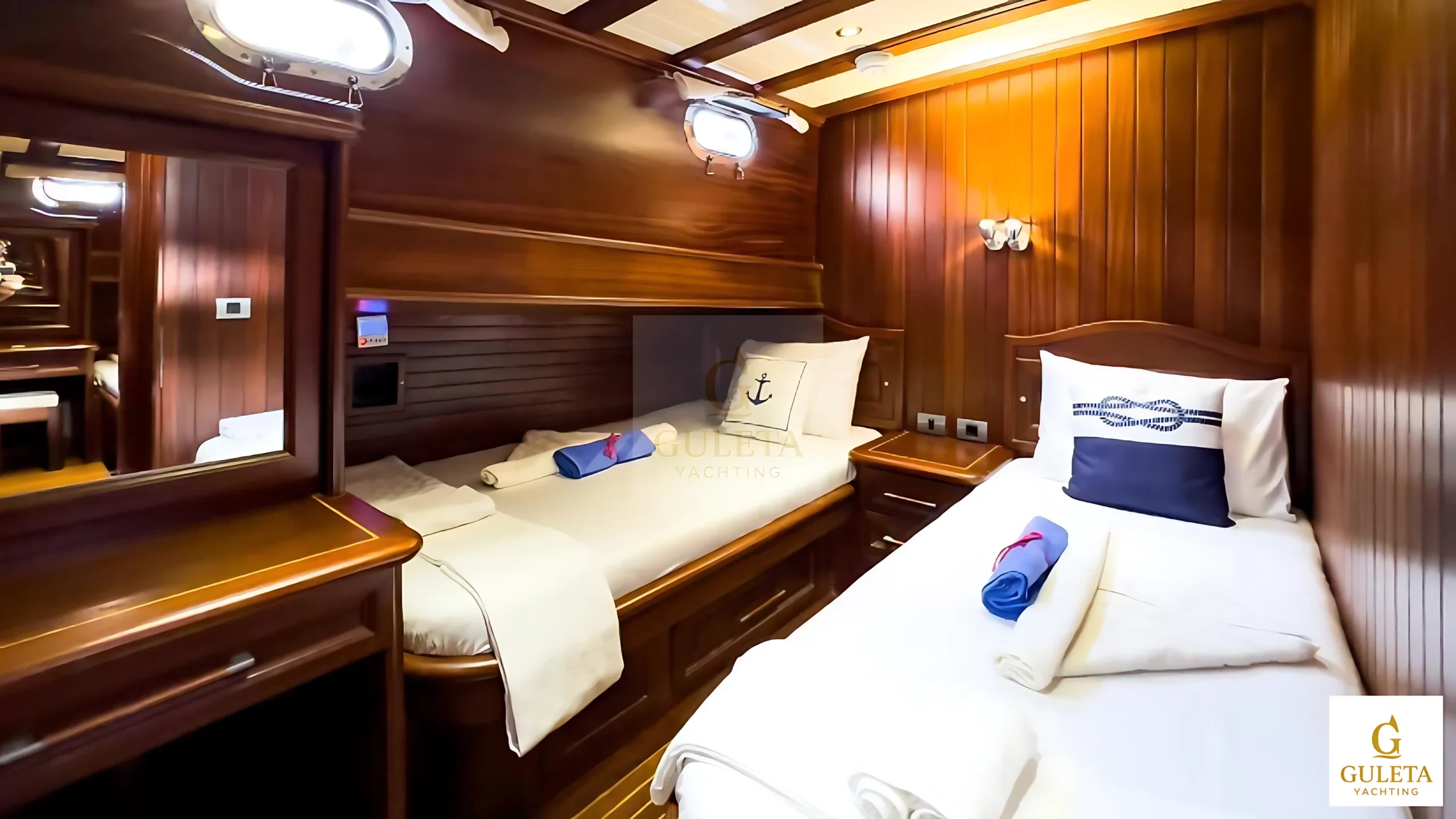 Sunrise 2 Gulet twin cabin featuring two single beds and porthole lighting.