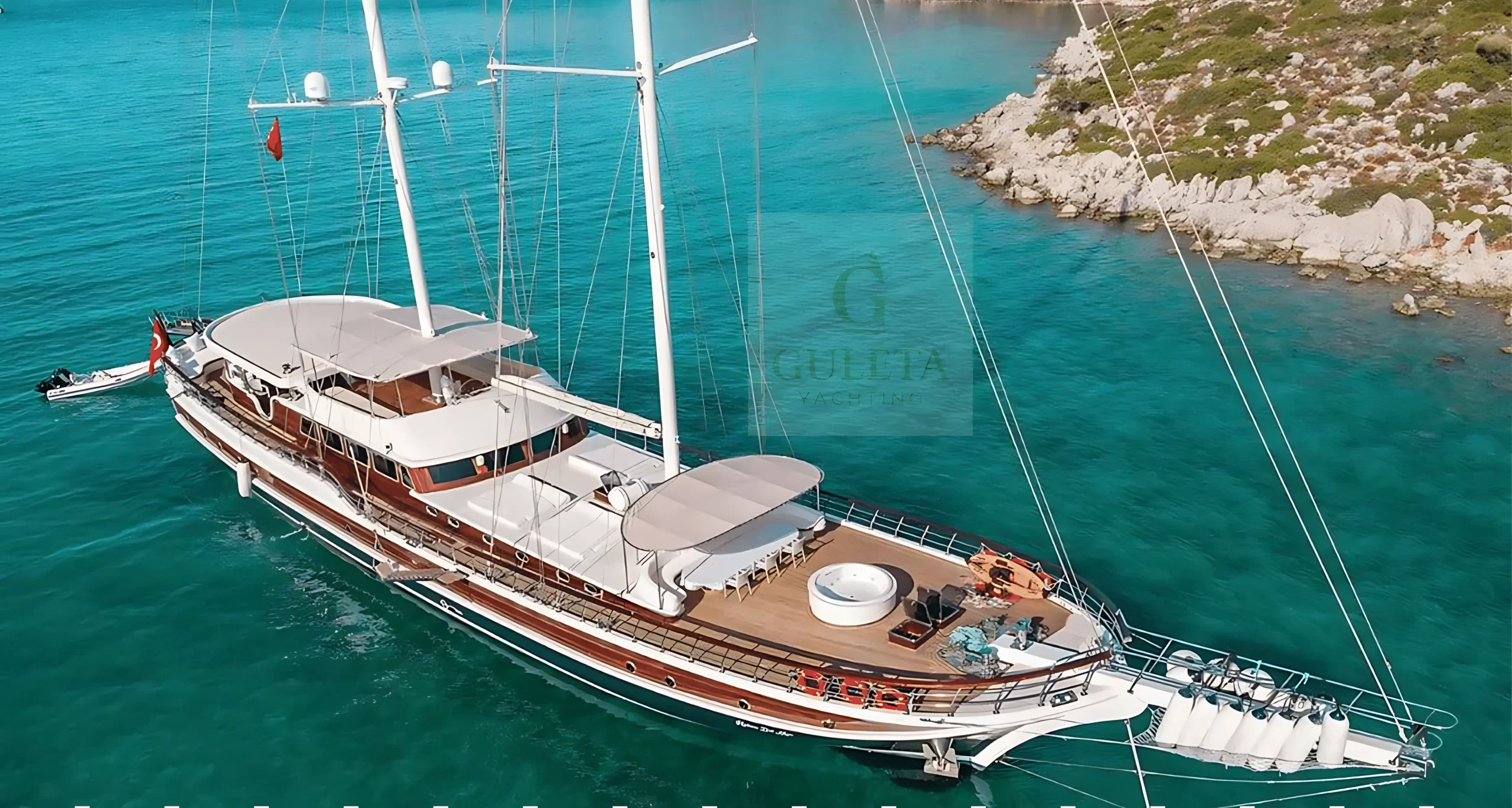Halcon Del Mar gulet photographed from outside during the day, showcasing her sleek wooden hull and spacious deck.