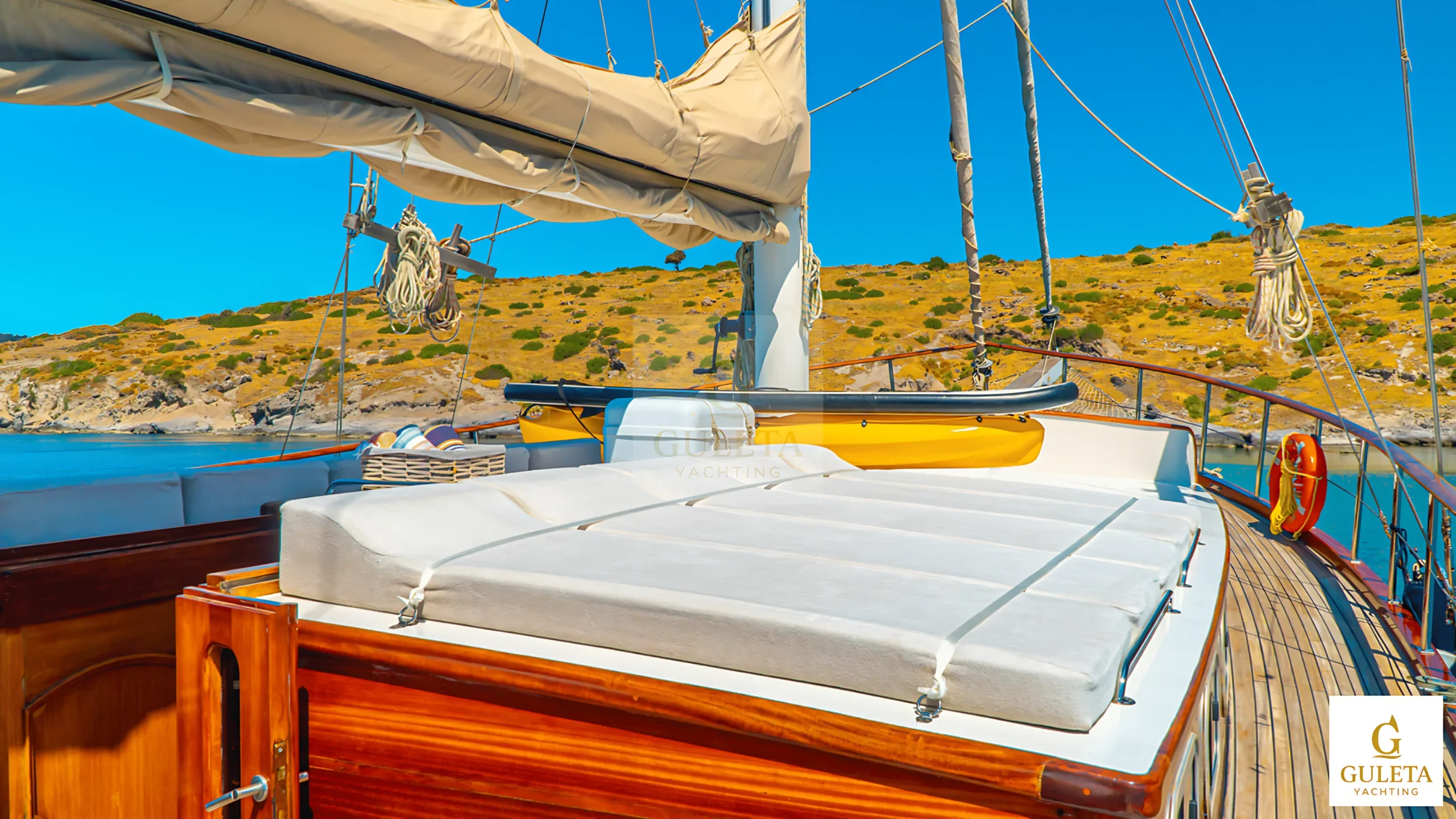 Forward-facing deck view of Avrasya Gulet with sunbathing cushions and panoramic sea backdrop.