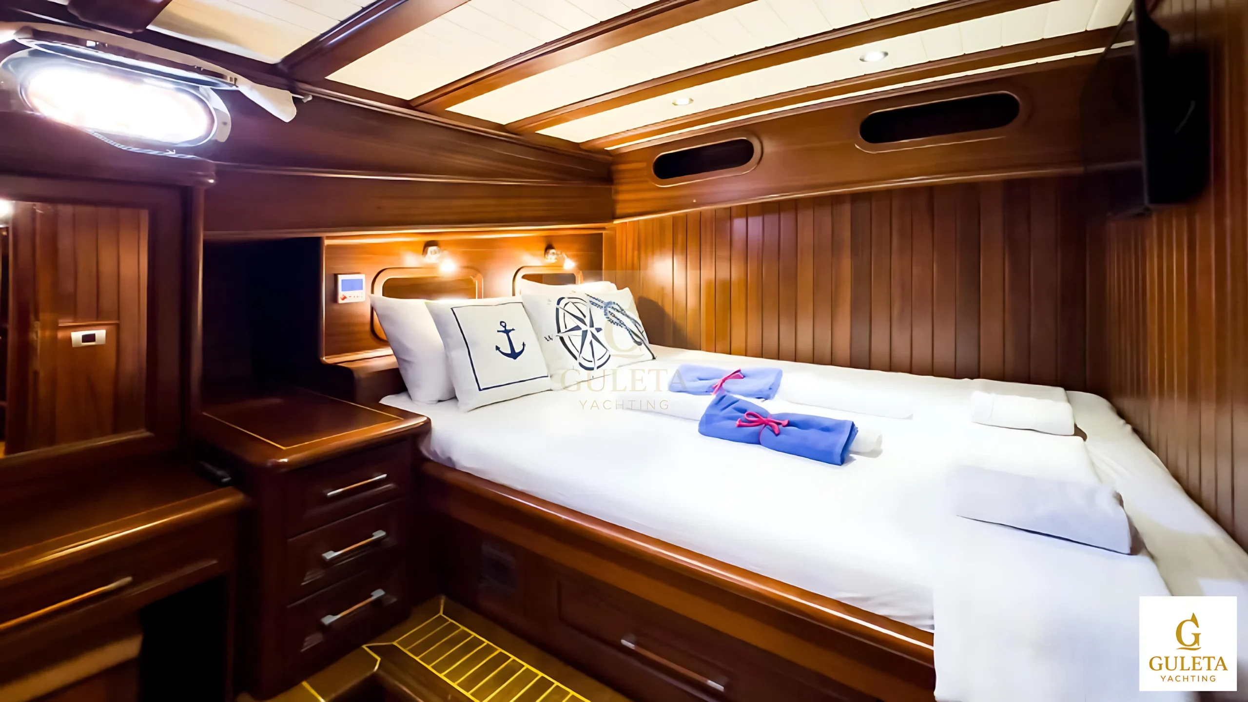 Sunrise 2 Gulet master cabin with cozy bedding and wooden interior.