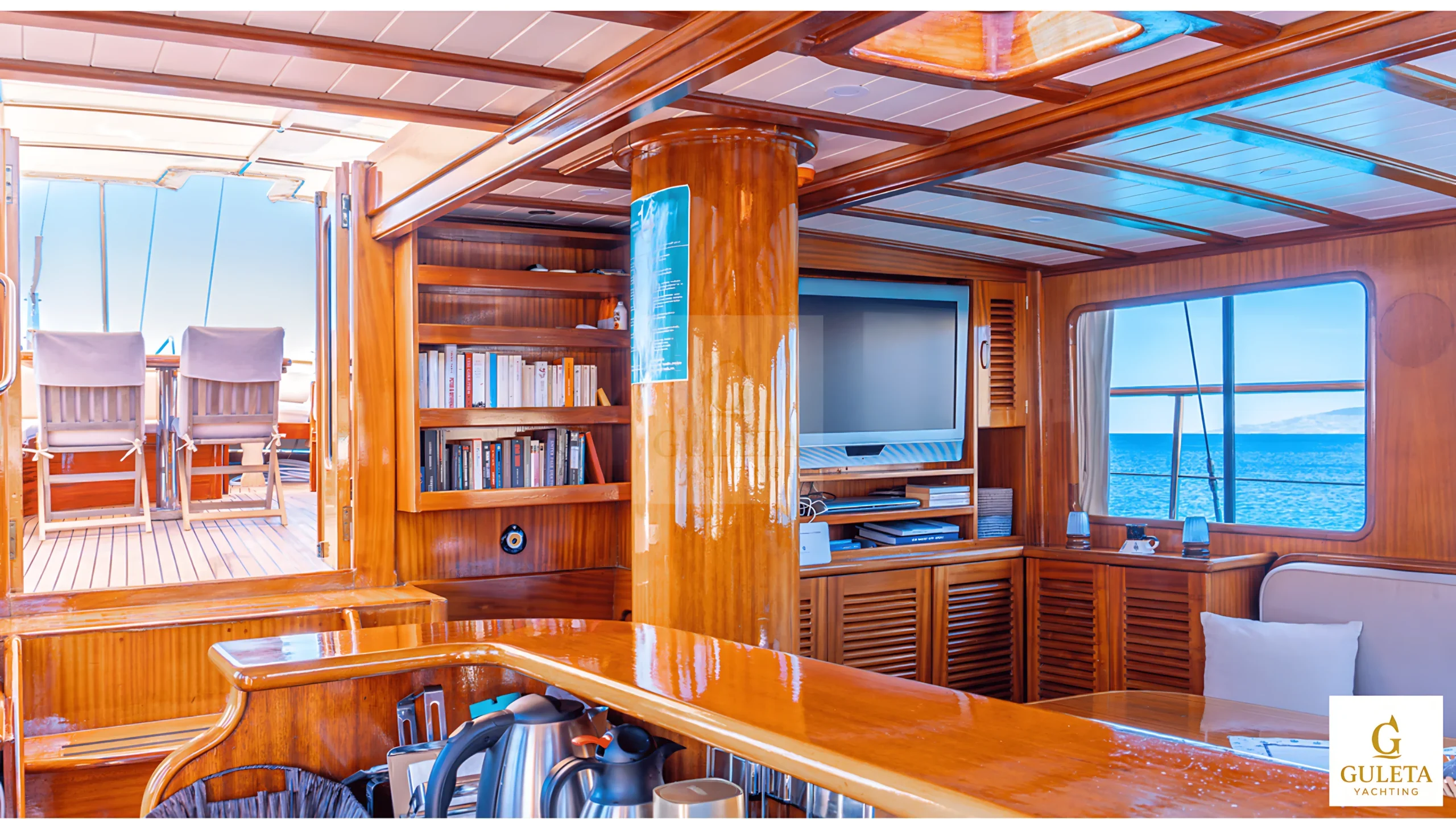 Interior perspective of Avrasya Gulet showing bookshelf, TV unit, and access to the deck.
