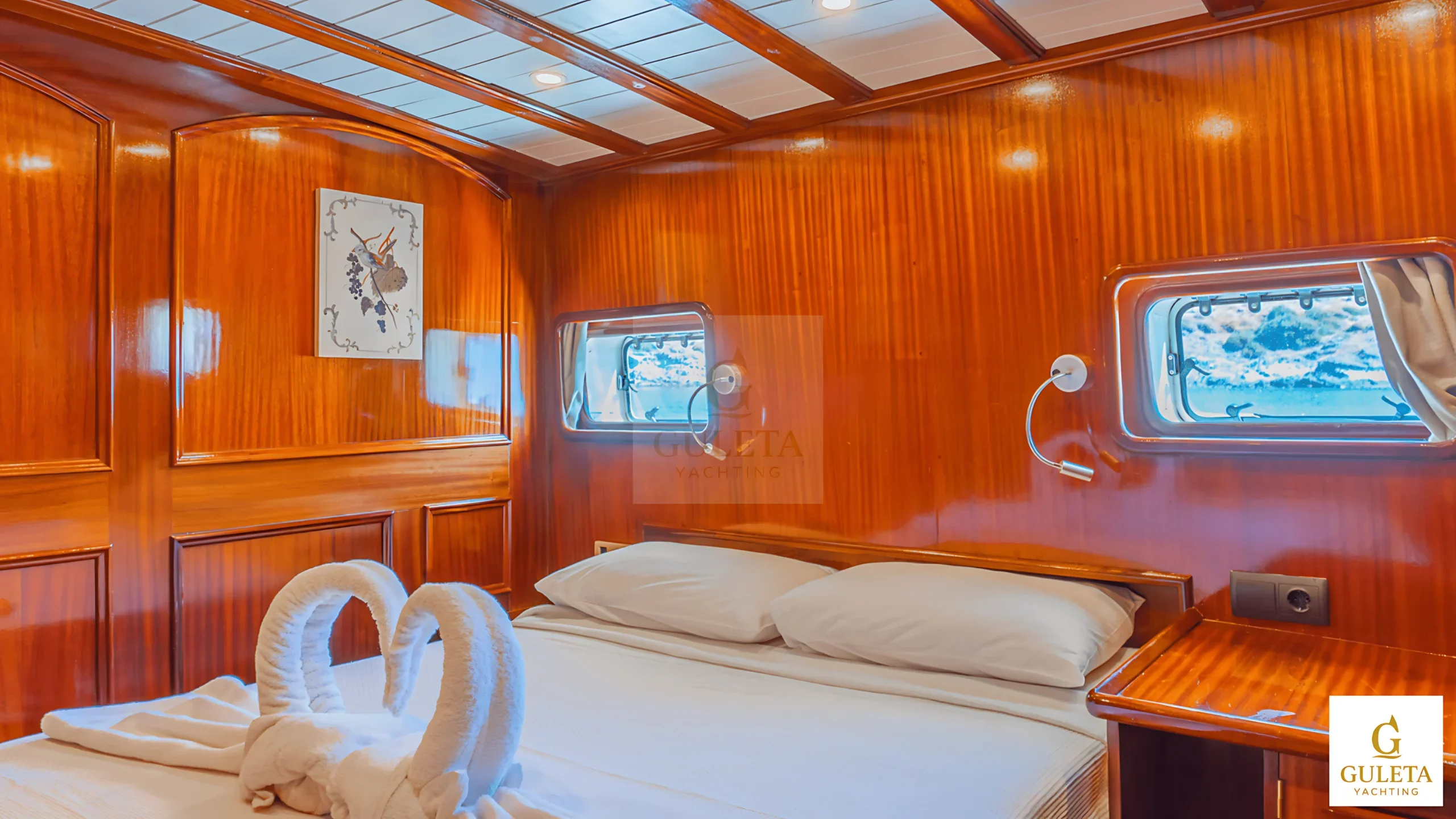 Master cabin of Avrasya Gulet with double bed, wood furnishings, and stylish lighting.