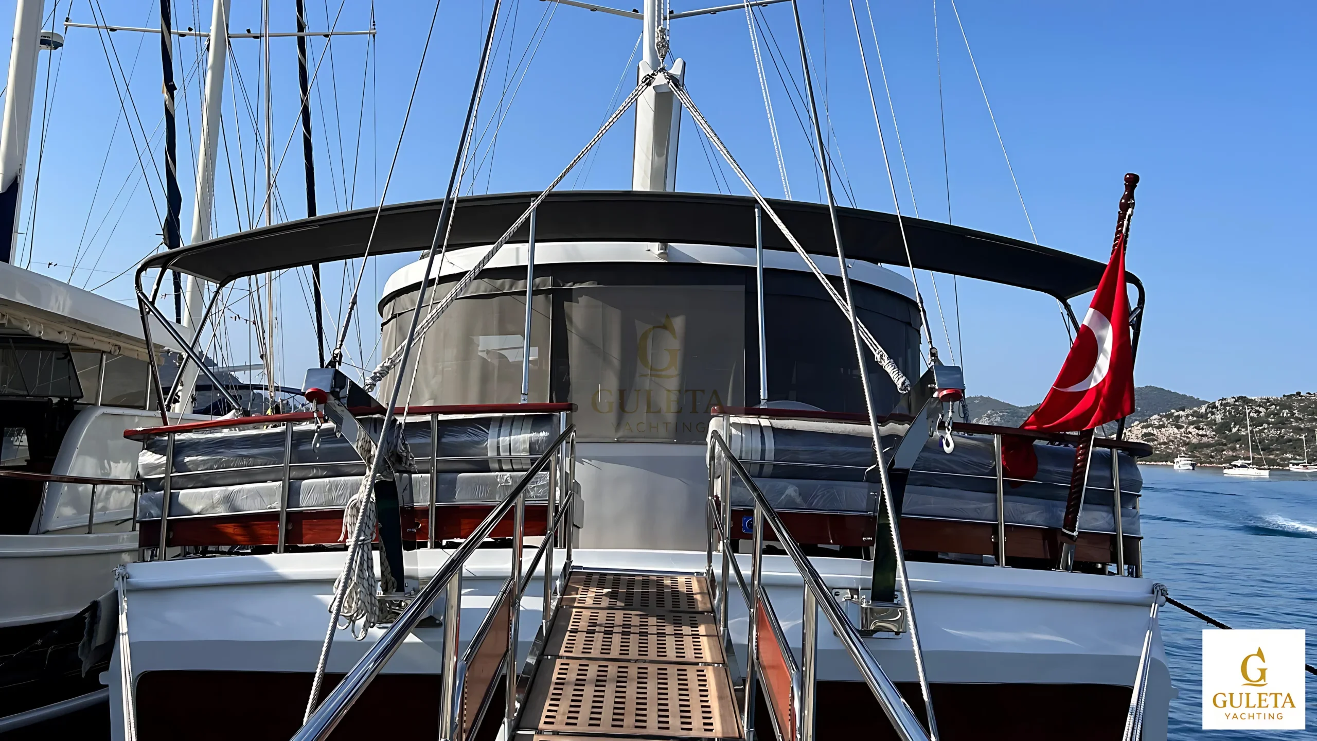 Sulyar Gulet seen from the aft deck with golden duotone effect, showcasing the yacht's elegant rear design and boarding platform.