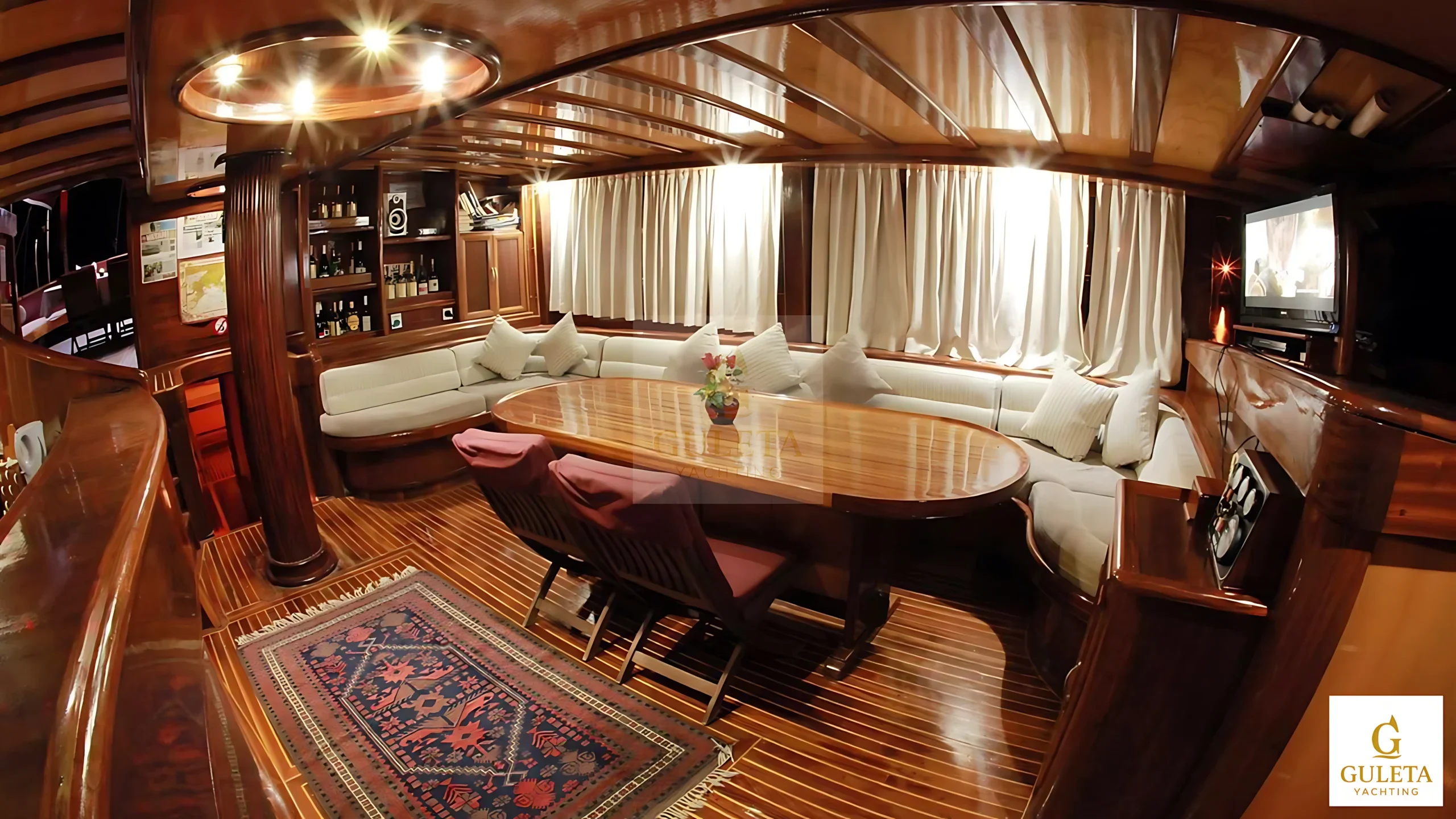 Nirvana Gulet saloon with seating area, TV, and bar for comfortable yacht charter in Turkey