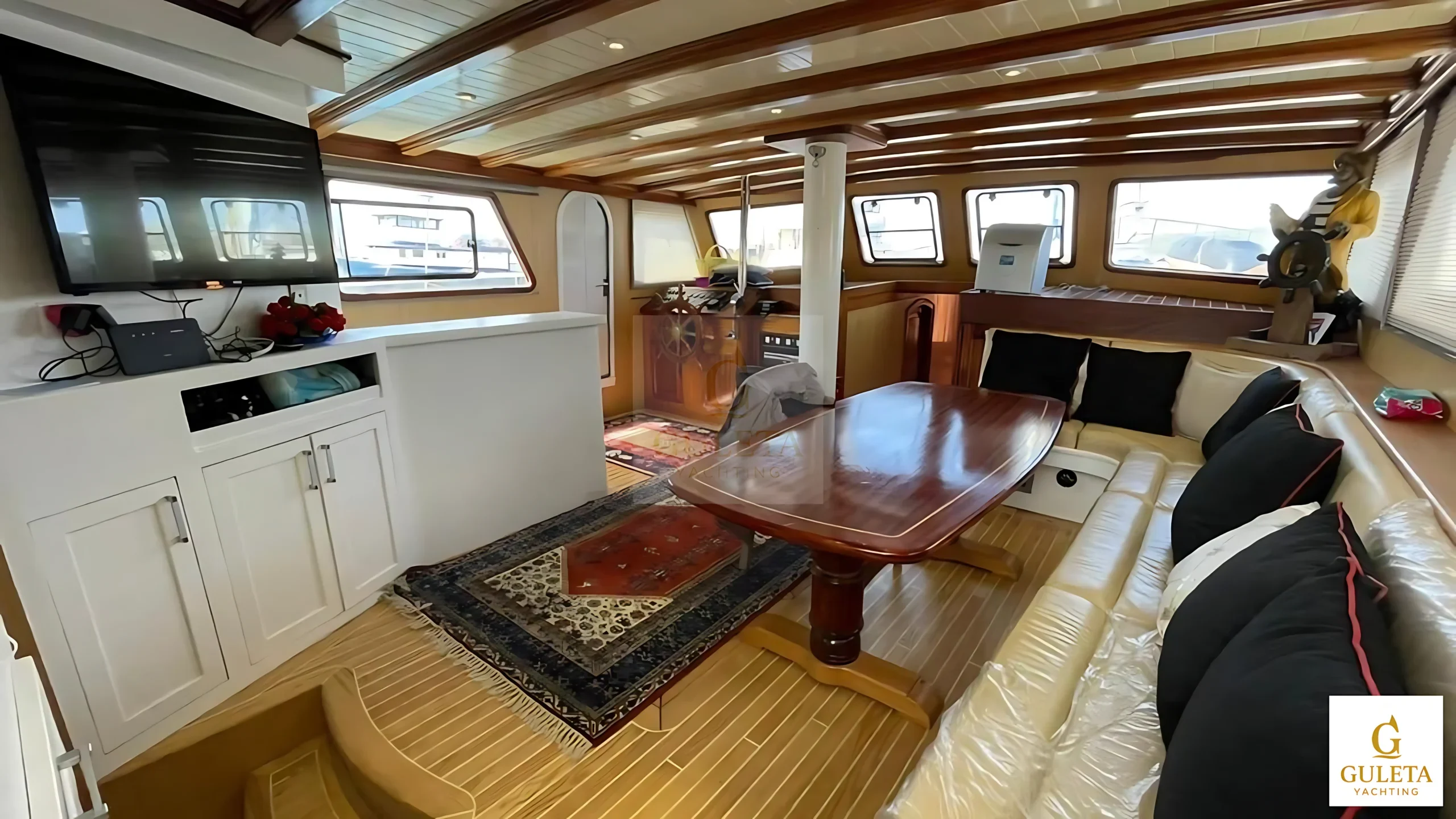 Wide view of Pam Due Gulet saloon with helm and TV